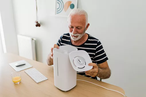 Senior Man in a new home who assembles Humidifier